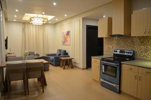 une cuisine et un salon avec un canapé et une table dans l'établissement Larissa Suites, à Khobar
