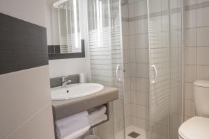 La salle de bains blanche est pourvue d'un lavabo et de toilettes. dans l'établissement Logis Hôtel Restaurant Chaptal, Amboise, à Amboise