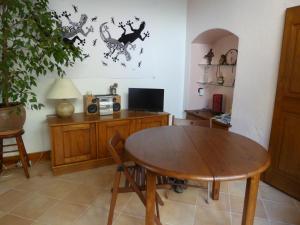a dining room with a table and a tv at Au pied des Alpes in Vaulnaveys-le-Haut