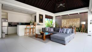 a living room with a couch and a kitchen at Chandra Bali Villas in Seminyak