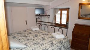 una camera da letto con un letto e una TV a parete di B&B La Casa Rosa a Balze