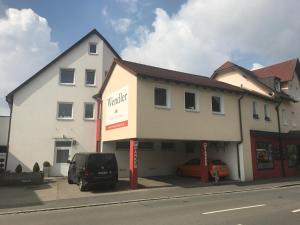 a white building with a van parked in front of it at Wendlers Ferienwohnungen #2 und #3 in Schwaig bei Nürnberg