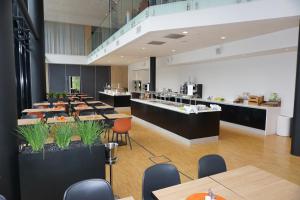 a restaurant with tables and chairs and a cafeteria at Pingvinhotellet UNN Tromsø in Tromsø