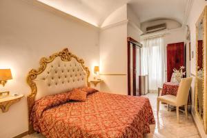 ein Schlafzimmer mit einem Bett, einem Tisch und einem Stuhl in der Unterkunft Hotel Virginia in Rom