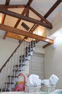 Pokój ze schodami z drewnianymi belkami stropowymi w obiekcie Flamingo Luxury Apartment AJPSARDINIA w Cagliari +37 zdjęć