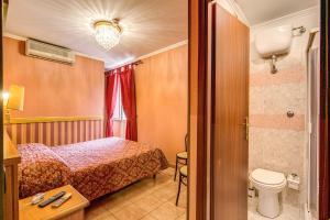 a hotel room with a bed and a toilet at Hotel Virginia in Rome