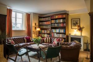 una sala de estar con sofá y una estantería llena de libros. en Hotel Nibelungenhof en Tulln