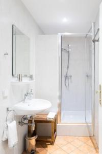 a white bathroom with a sink and a shower at Hotel Nibelungenhof in Tulln