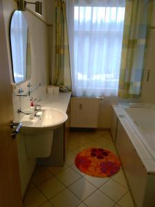 a bathroom with a sink and a tub and a mirror at Apartmánek U lanovky in Janske Lazne