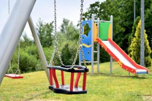 Tres columpios en un parque con parque infantil en Zajazd Partynia, en Partynia