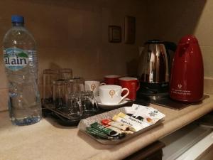 een aanrecht met een fles water en glazen bij فندق الأصيل ألوان الفندقية in Mekka