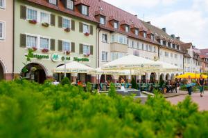 ein Gebäude mit Tischen und Sonnenschirmen davor in der Unterkunft Hotel Gasthof Jägerstüble in Freudenstadt