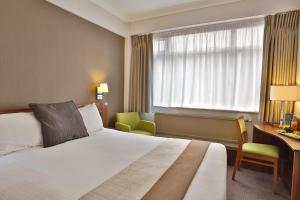 オルトリンシャンにあるBest Western Manchester Altrincham Cresta Court Hotelのベッド、デスク、窓が備わるホテルルームです。