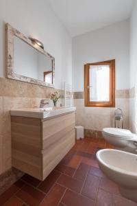 フィレンツェにあるRoommo Borgoのバスルーム(洗面台2台、トイレ、鏡付)