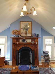 a fireplace in a living room with blue walls at Water Bay Villa Bed & Breakfast in Adelaide