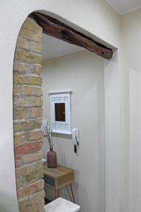 Pokój z ceglaną ścianą i lustrem w obiekcie Flamingo Luxury Apartment AJPSARDINIA w Cagliari