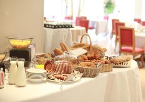 - une table avec un buffet de pain et de viennoiseries dans l'établissement Hôtel & Spa Château de l'ile, à Ostwald