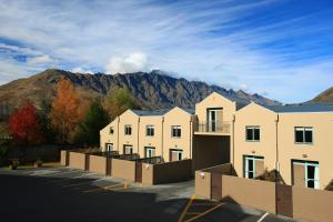 a row of houses in front of a mountain at Queenstown Gateway Apartments in Queenstown