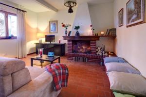 a living room with a couch and a fireplace at Villetta La Pineta in Latignano