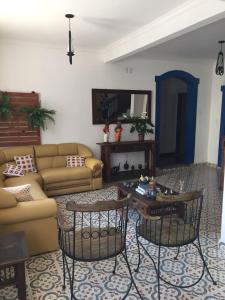 a living room with a couch and a table and chairs at Pousada Sinhá Moça in São João del Rei