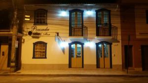 a building with doors and windows at night at Pousada Sinhá Moça Campos Ltda in São João del Rei