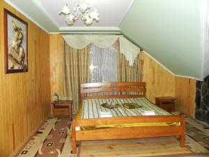 a bedroom with a wooden bed in a room at Hotel and restaurant complex Skolmo in Klevanʼ