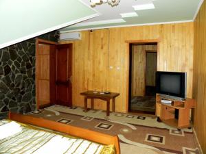 a room with a tv and a bed and a table at Hotel and restaurant complex Skolmo in Klevanʼ