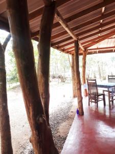 einem Holzpavillon mit Stühlen und einem Tisch in der Unterkunft Aralu Habarana Resort in Habarana