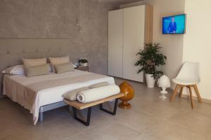 a bedroom with a bed, desk, chair, and lamp at Avantgarde Hotel in Conversano