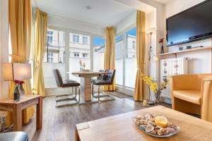 a living room with a table and a desk with chairs at Haus Meerblick - 15 in Ahlbeck