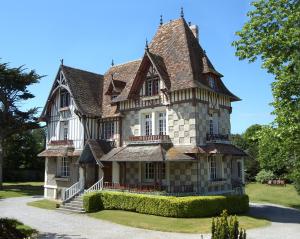 uma casa velha com um telhado de gambrel em Le Clos des Pommiers em Blainville-sur-Mer
