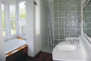 ein Badezimmer mit einer Badewanne, einem WC und einem Waschbecken in der Unterkunft Le Clos des Pommiers in Blainville-sur-Mer