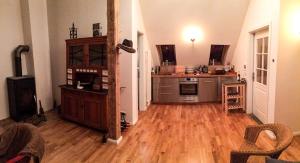 a room with a kitchen with a wooden floor at Appartement Alte Schmiede in Lübbenow