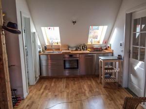 a kitchen with stainless steel appliances and wooden floors at Appartement Alte Schmiede in Uckerland