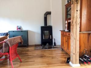 a living room with a wood stove and a chair at Appartement Alte Schmiede in Uckerland