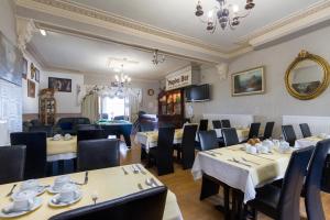 ein Restaurant mit Tischen und Stühlen in einem Zimmer in der Unterkunft Maples Hotel in Blackpool