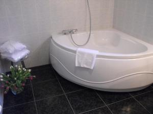 a white bath tub in a bathroom with a toilet at L'Orée des Chênes, The Originals Relais (Relais du Silence) in La Ferté-Saint-Aubin