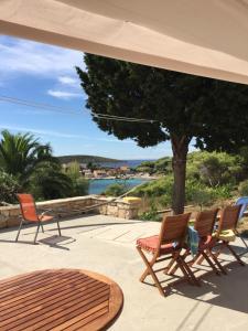 a patio with chairs and a table and a tree at Bargujac Summer House in Vis