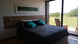 a bedroom with a bed and a large window at Amatxi in Los Reartes