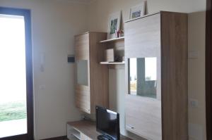 un soggiorno con TV e mobile in legno di Appartamento Lago di Garda Albisano a Torri del Benaco