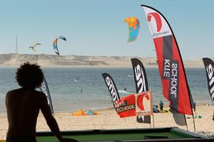 a woman standing on a beach next to a kite at Hotel Dakhla Club in Dakhla