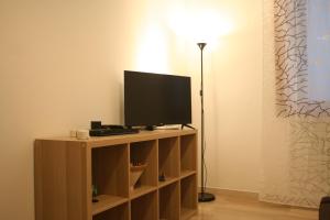 a flat screen tv on a stand with a lamp at Casa Palladio in Vicenza