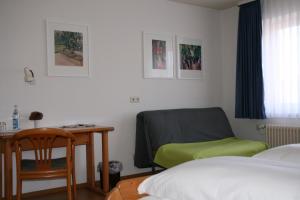 a bedroom with a desk and a bed and a chair at Sontheimer Wirtshäusle in Sontheim im Stubental
