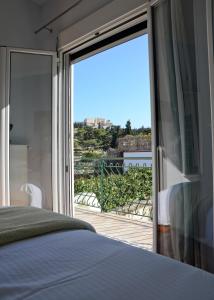 a bedroom with a large glass door leading to a balcony at Meros - Athenian Residencies in Athens