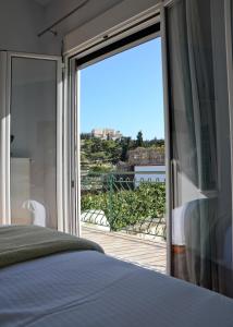アテネにあるMeros - Athenian Residenciesのベッドルーム1室(バルコニーへ続く大きなガラスドア付)