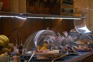 a buffet with food in a glass dome on a table at Hotel A Pinnata in Lipari