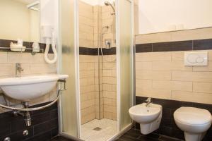 a bathroom with a shower and a toilet and a sink at Hotel Okinawa in Rimini