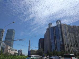 a city with cars driving down a street with buildings at 7Days Premium Beijing Dongzhimen Airport Express Station in Beijing