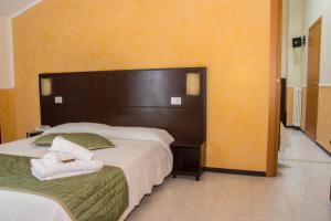 a hotel room with two beds and a large headboard at Hotel Okinawa in Rimini