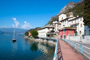 a river with buildings and a boat in the water at Casa Lory in Marone